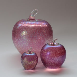 Handmade glass apples in iridescent pink