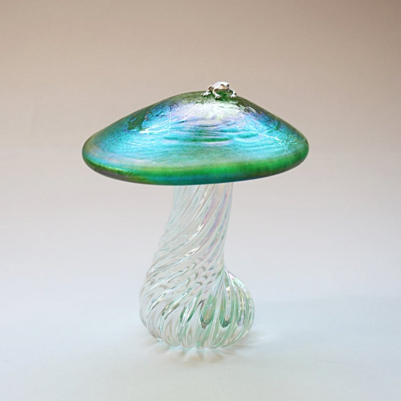 silver frog sitting on an iridescent green handmade glass toadstool