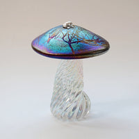silver frog sitting on an iridescent handmade glass toadstool