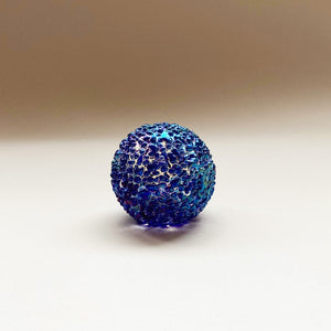 small round blue speckled glass paperweight